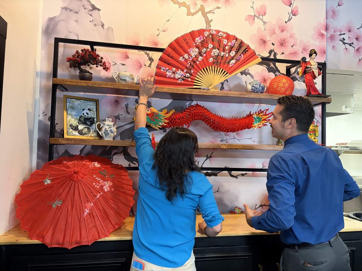 Ariel Johnson, left, and her brother, Greg Spornhauer, hang a dragon on the China display at Good ‘n Plenty Steak House and International Buffet, a new family owned and operated restaurant expected to open in August in Warner Robins. Johnson is over marketing and Spornhauer is the co-owner and over operations of the restaurant. The interior features displays of countries from which food is featured on the buffet.