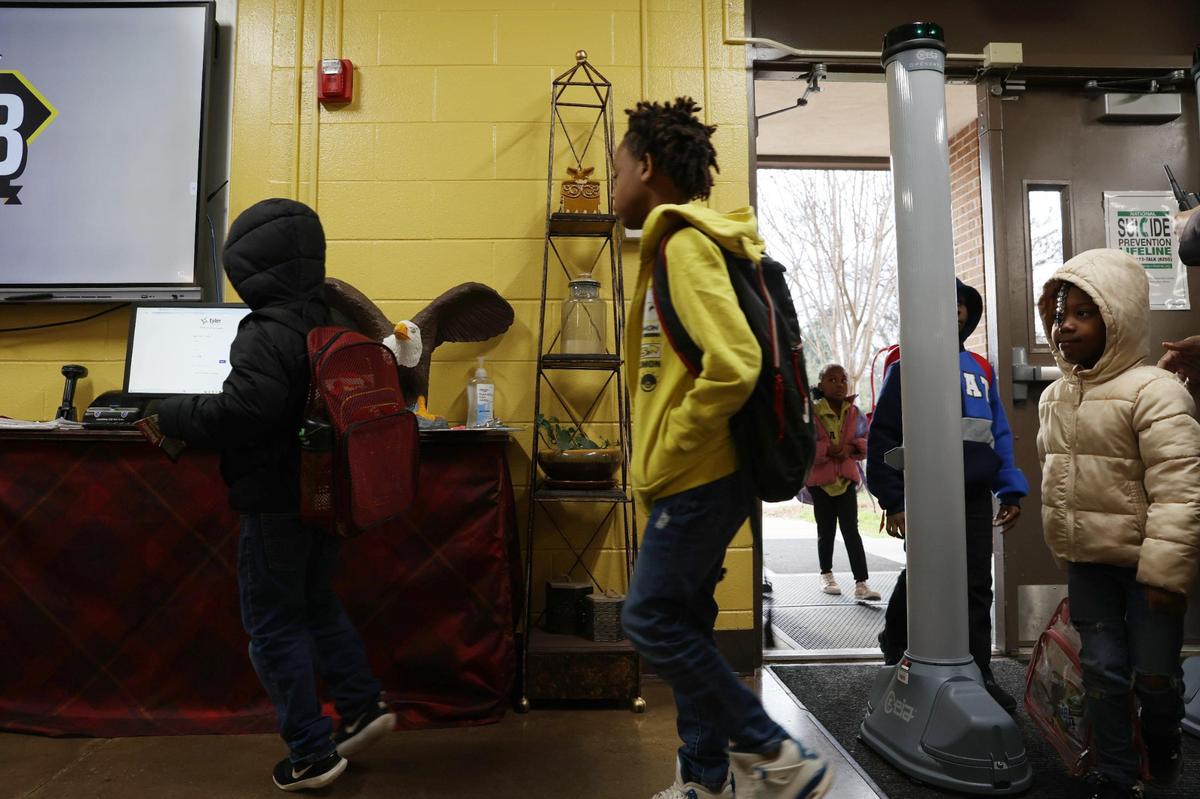 Students walk into L. H. Williams Elementary School on the first day after February break on Thursday, Feb. 20, 2025, in Macon, Georgia. Members of the Macon Rampage, Macon’s semi-professional football team, welcomed students to school on the first day back from February break as a a part of the United Way’s Walking School Bus initiative to encourage student attendance.