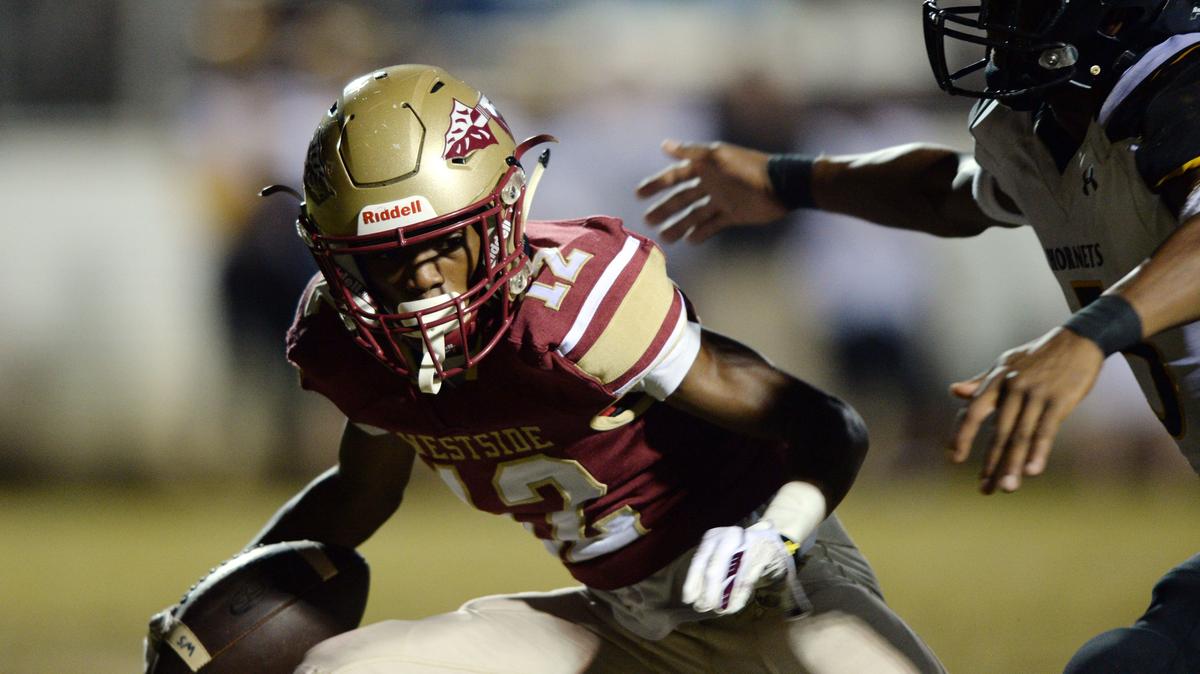 Westside wide receiver Scooter Risper (12) tries to sidestep a Cook defensive back as he heads toward the goal line with a pass from Victor Dixon.  The Seminoles scored on the next play with a 2-yard run by Tyshaun Freeman giving them a 13-6 lead in the second quarter.