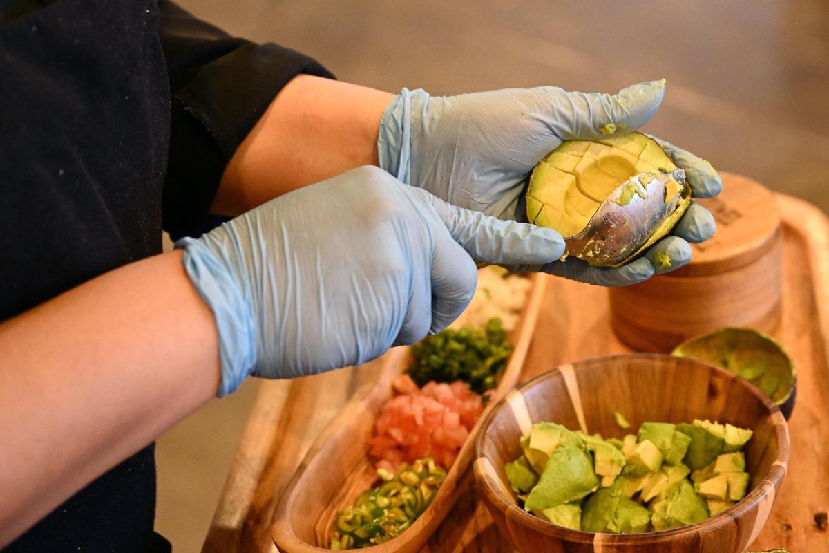 Co-owner Alma Valencia scoops avocado for fresh made guacamole at Cozumel Mexican Grill on Wednesday, April 23, 2025, in Perry. The restaurant’s chunky guacamole is made fresh at the table for customers.