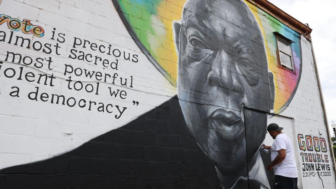 Kevin “Scene” Lewis touches up his mural of civil rights leader John Lewis on Monday, June 24, 2024, off of South Commercial Circle in Warner Robbins, Georgia. Lewis repainted parts of the mural after it was defaced on Friday.