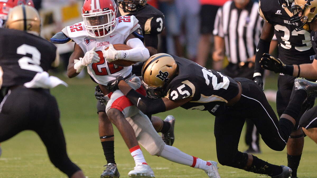 Jackson Red Devil Antavius Grier gets brought down by Mary Persons defender Vic Henderson during first quarter action Friday night.