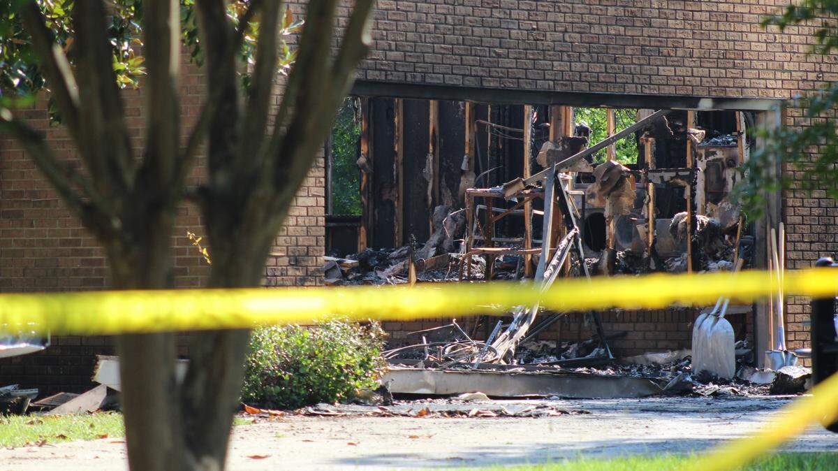 A brick home was destroyed and covered in soot on the morning of Friday, Aug. 15, 2025, a day after a fire that left a man dead at 109 Horseshoe Drive in Warner Robins, Ga. The scene was surrounded by yellow tape while firefighters investigated the cause of the fire.