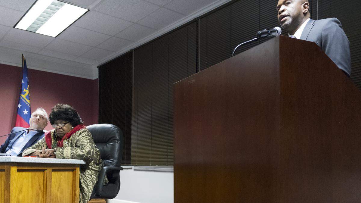 Eric Thomas, the state's chief school turnaround officer, makes his pitch to Bibb County school board members, including Lester Miller, left, and Wanda West, on Thursday..