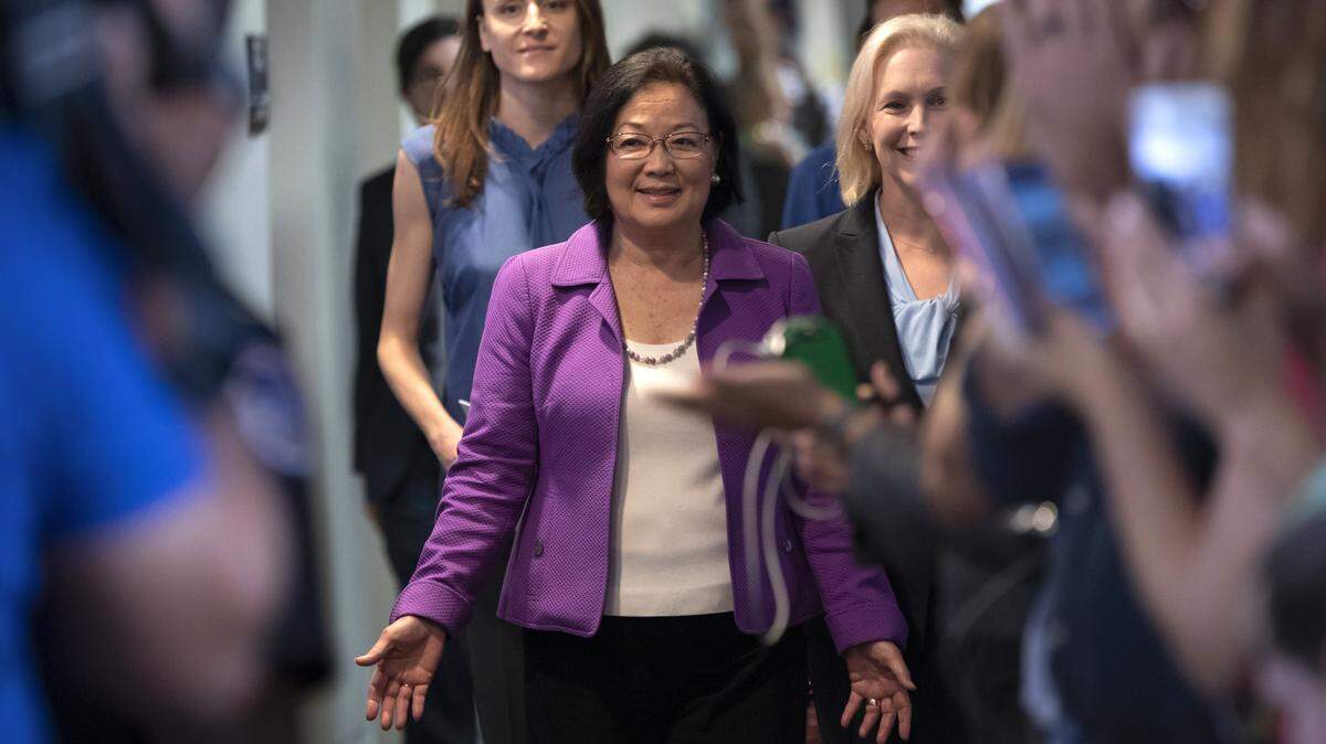 Sen. Mazie Hirono, D-Hawaii, flanked by Sarah Burgess, left, an alumnae of the Holton Arms School, and Sen. Kirsten Gillibrand, D-N.Y., right, is applauded by demonstrators as they arrive to speak to reporters in support of professor Christine Blasey Ford, who is accusing Supreme Court nominee Brett Kavanaugh of a decades-old sexual attack, during a news conference on Capitol Hill in Washington last week.