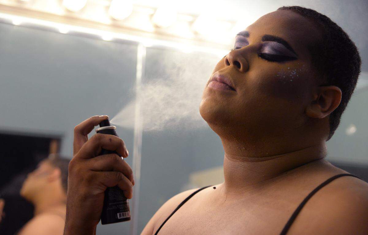 Christina Leon, show director and host of The Tribe, sprays make up setting spray on her face in the dressing room at the Hargray Capitol Theatre on Friday before Macon Pride’s House Party event featuring the well-known drag queen Lala Ri.