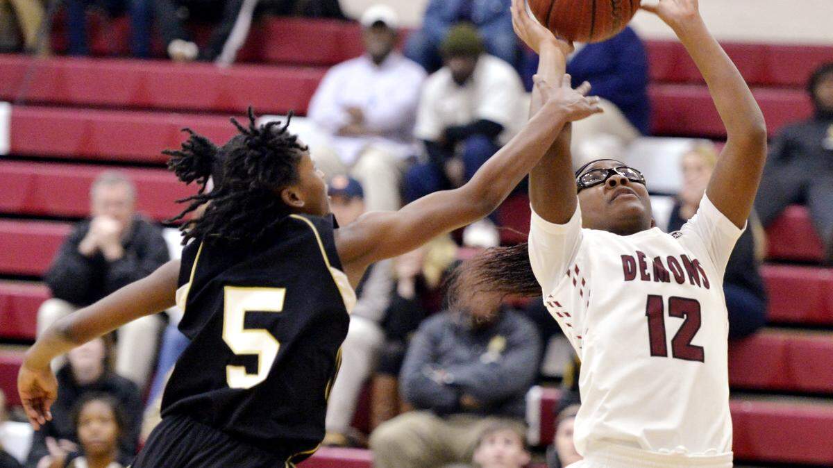 Warner Robins Le'terria Mathis (12) puts up a shot over Mary Persons Kver Shannon (5) during their game Tuesday night.