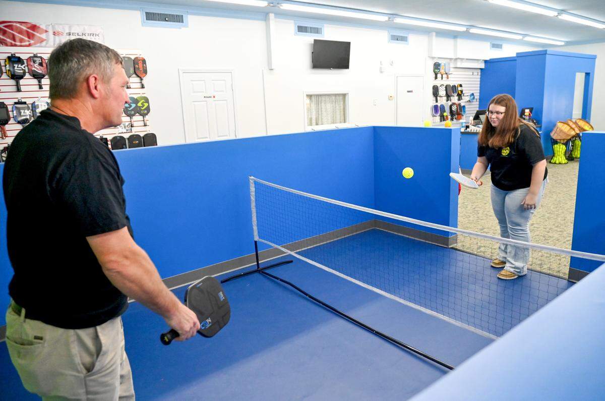 Owner Greg Stokes and his daughter Brayden Stokes demonstrate the small court at Pickleball Sports at 4446 Forsyth Road in Macon.