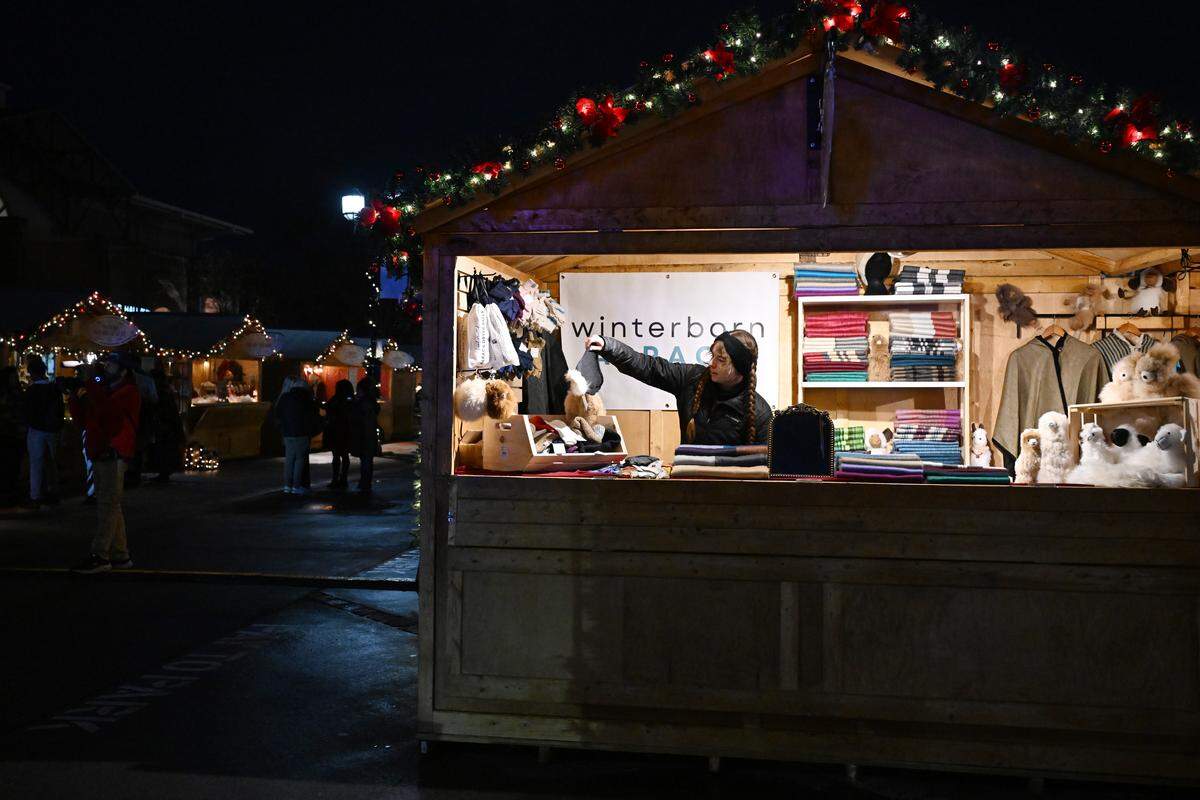 Winterborn Alpaca manager Bridget Sharon, from Calgary, Alberta, hangs up alpaca gloves inside her stand at Marchè de Noel during a preview opening on Thursday, Dec. 4, 2025, in downtown Macon, Georgia. The inaugural Macon Christmas Market is modeled after a traditional European Christmas market and features a number of small business vendors. 