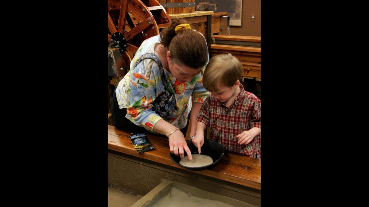 Alanna Young and her 3-year-old son, Coleman, pan for gems in an interactive exhibit at the Tellus Science Museum in Cartersville. This file photo was taken in 2009.