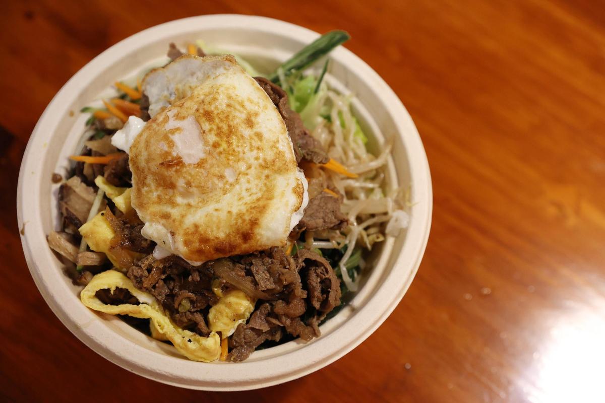 The classic bibimbap, a Korean rice dish that includes sautéed vegetables, bulgogi and a fried egg, sits on the counter on Tuesday, Jan. 14, 2024, at Gangnam Grill in downtown Macon, Ga. The new casual, fast paced Korean restaurant sits in the space where Ninja Steakhouse and Sushi used to be, but with the same family ownership.