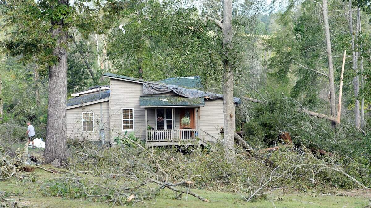 Wayne Granade, left, walks through the twisted trees on the ground near his home at Flint River Estates where he saw the tops of big trees coming at him from a ferocious wind in October.