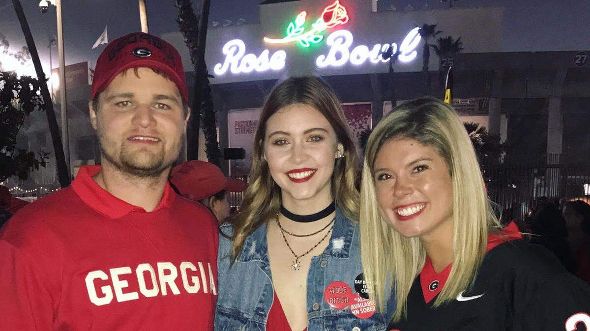 Georgia fans Connor Paul, Maggie Lamb and Anna Parks pose for a photo outside of the Rose Bowl.