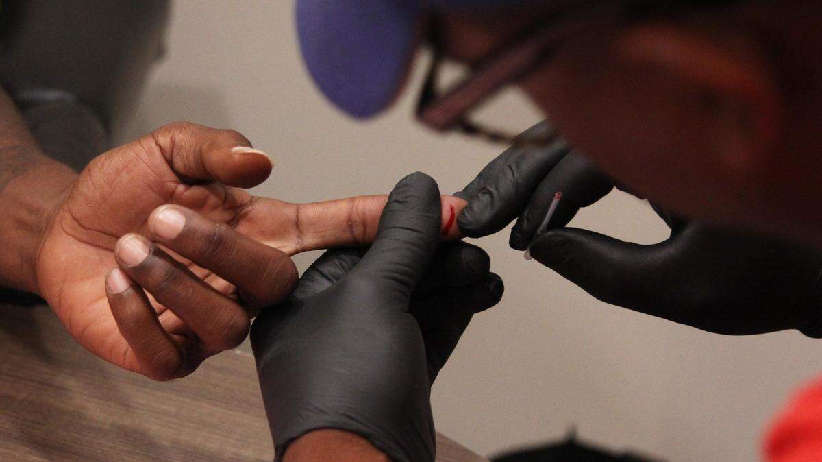 DeMarcus Beckham, HIV/AIDS advocate in the North Central Public Health district, performs a demonstration of an HIV test at a clinic in Macon. Rapid HIV blood tests take less than five minutes for results.