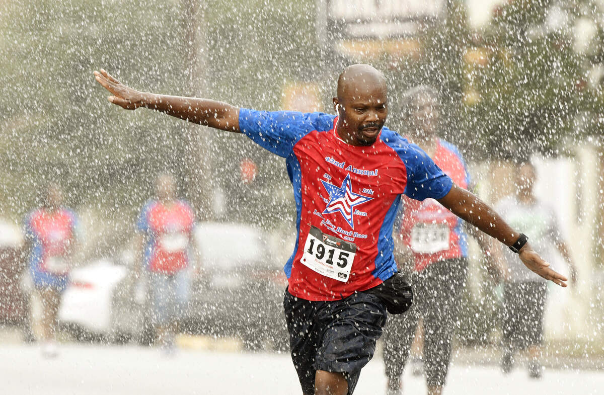 A runner cools off in a water shower provided by the Macon-Bibb Fire Department on D.T. Walton Sr. Way on Sept. 3 during the Macon Labor Day Road Race.