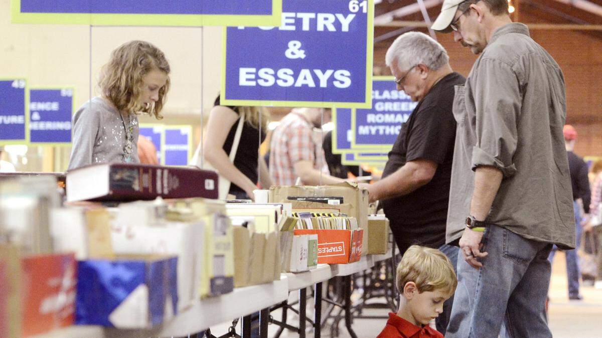 JASON VORHEES/THE TELEGRAPHChristian Willis, 6, looks through a book during the 2014 Friends of the Library Old Book Sale at Central City Park.
