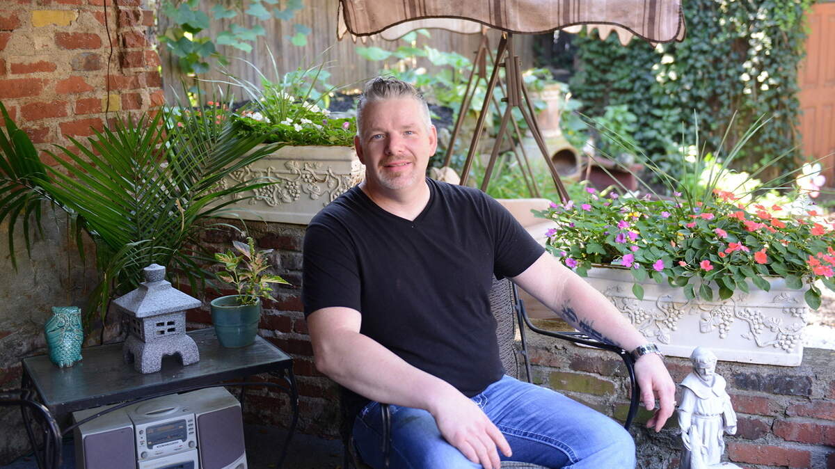 Lonnie Hoey poses for a portrait July 30 in front of his his backyard garden in Pittsburgh.