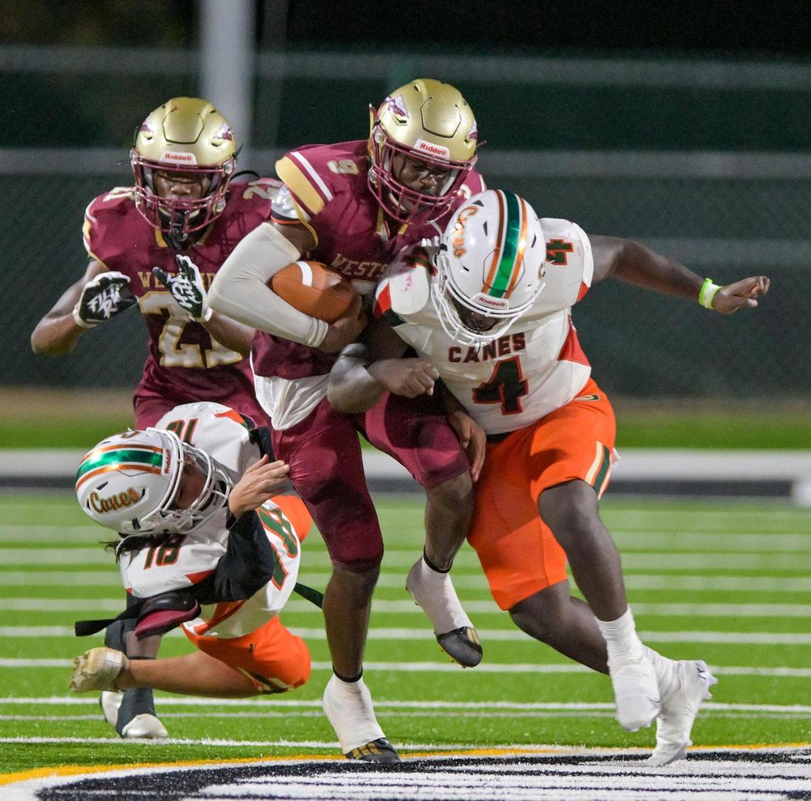 Westside’s Nathaniel Thrash get tackle by two Rutland defenders (4) Jacori Brown and (18) Brandon Elliott in action Friday night as the strolled to easy victory.
