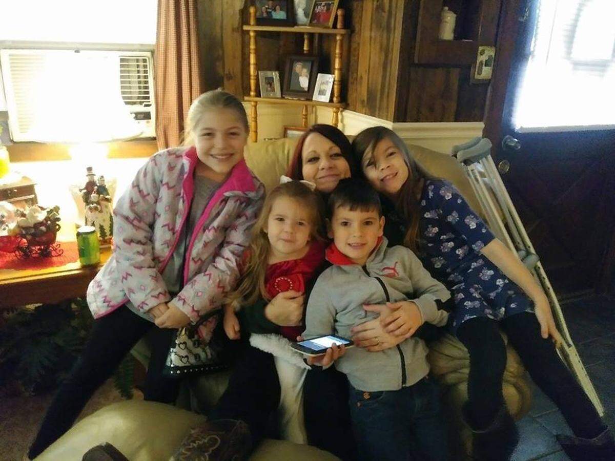 Jessica Wooten sits with her four children after one of her hip surgeries.