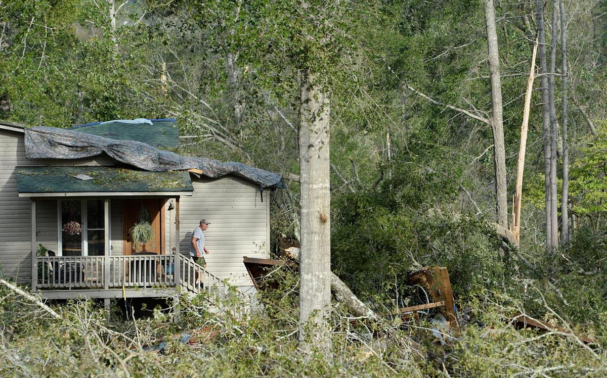 Wayne Granade steps out of his home where he survived a barrage of twisted treetops in an Oct. 11 storm.