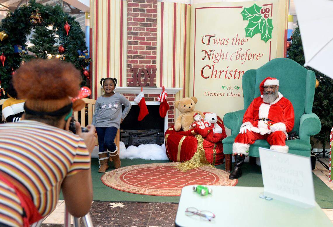 Dwight Miller, also known as Pop Popp Santa, poses for a picture with Taylor Woods, 7, of Perry Tuesday at the Houston County Galleria. According to the Galleria’s manager, Miller is the first Black Santa at the Mall.