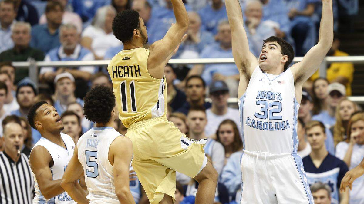 Georgia Tech's Josh Heath (11) goes to the basket against the defense of North Carolina's Theo Pinson, left, Marcus Paige (5) and Luke Maye (32) during the first half of an NCAA basketball game Saturday, Jan. 2, 2016, in Chapel Hill, N.C. (AP Photo/Ellen Ozier)