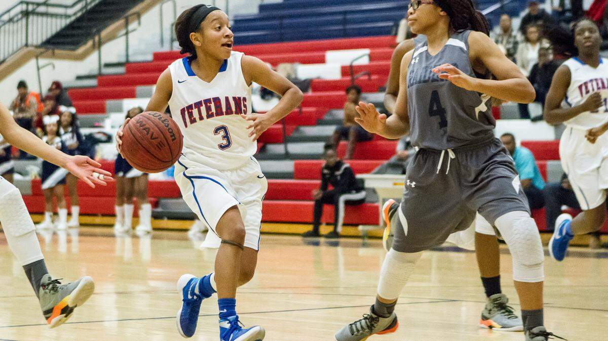 Veterans' Kya Cochran (3) splits 2 Redan defenders in the lane in the second round of the GHSA Class AAAA basketball playoffs.