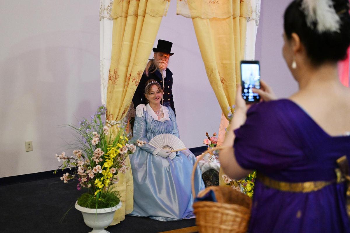 Lee Ford-Faherty (left) and John Faherty pose for a picture in a photo area at Queen Elizabeth’s Royal Ball at the Anderson Conference Center on Saturday, April 26, 2025, in Macon, Georgia. Ford-Faherty spent months before the event sewing outfits for herself and her husband.