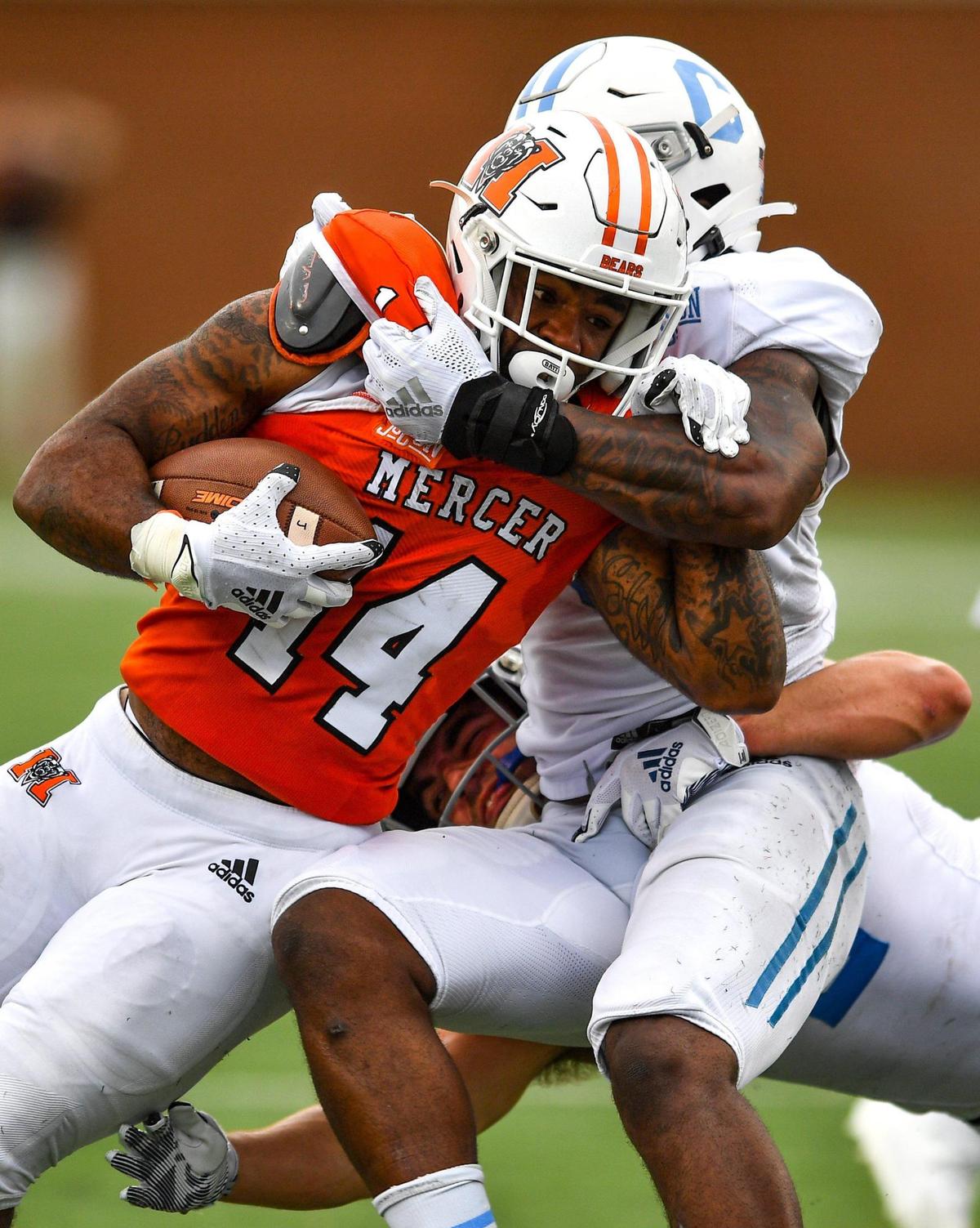 DONN RODENROTH,Macon, Georgia, 02/27/2021: Mercer running back Nakendrick Clark gets hauled down by a couple Citadel defenders in action Saturday in Macon.