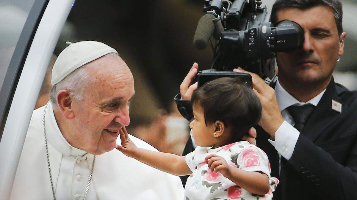 Pablo Martinez Monsivais/associated pressA child reaches out to touch the pontiff’s face during a parade in Philadelphia.