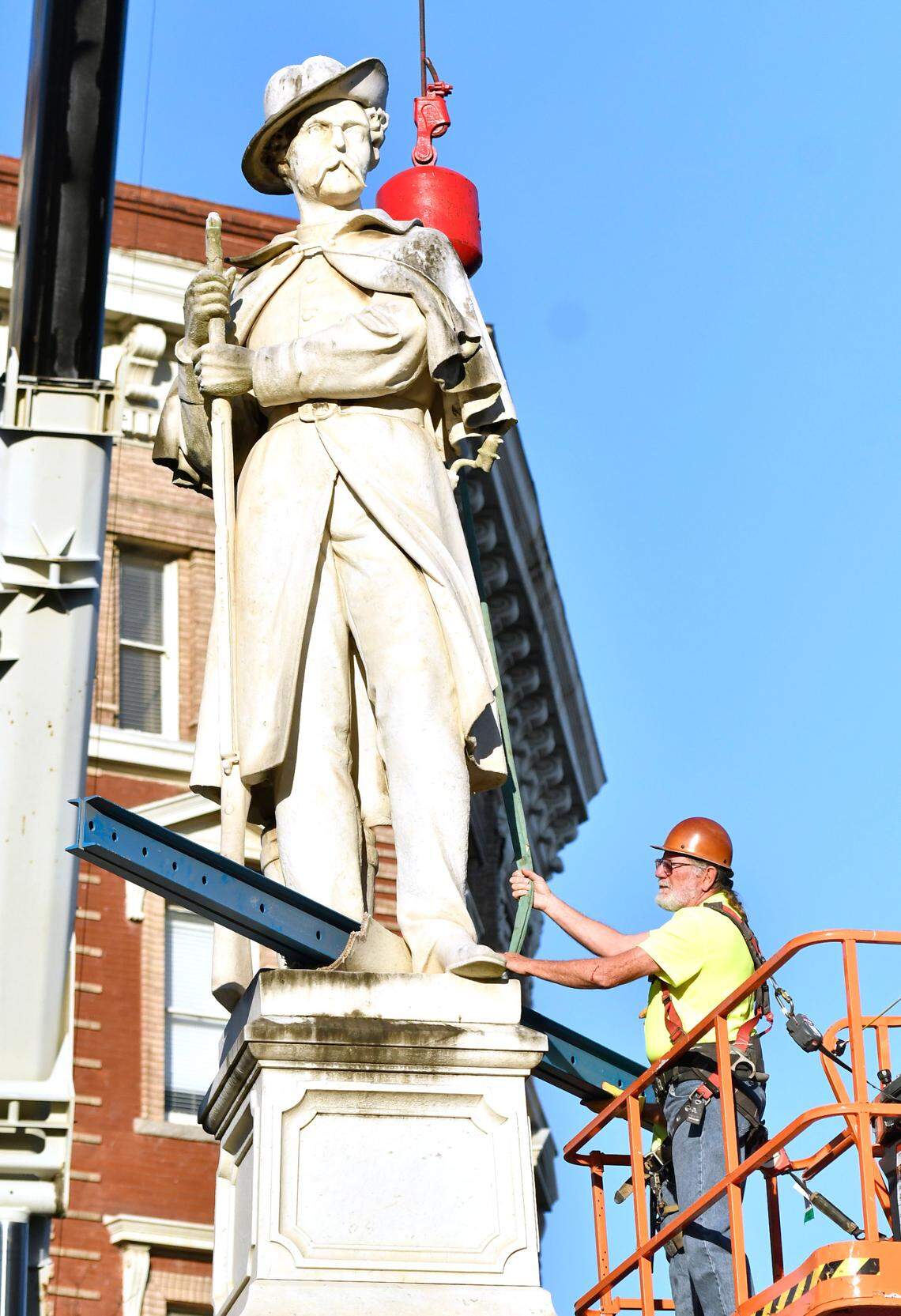 Crews work on securing the Confederate monument on Cotton Avenue before removing it Wednesday morning. The monument will be relocated to Whittle Park in from of Rose Hill Cemetery.
