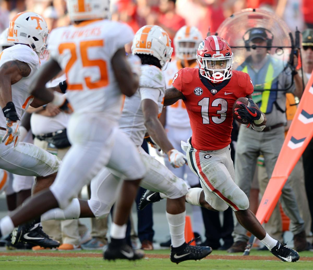 Georgia running back Elijah Holyfield (13) rushes for a first down during fourth quarter action. Georgia beat Tennessee, 38-12.