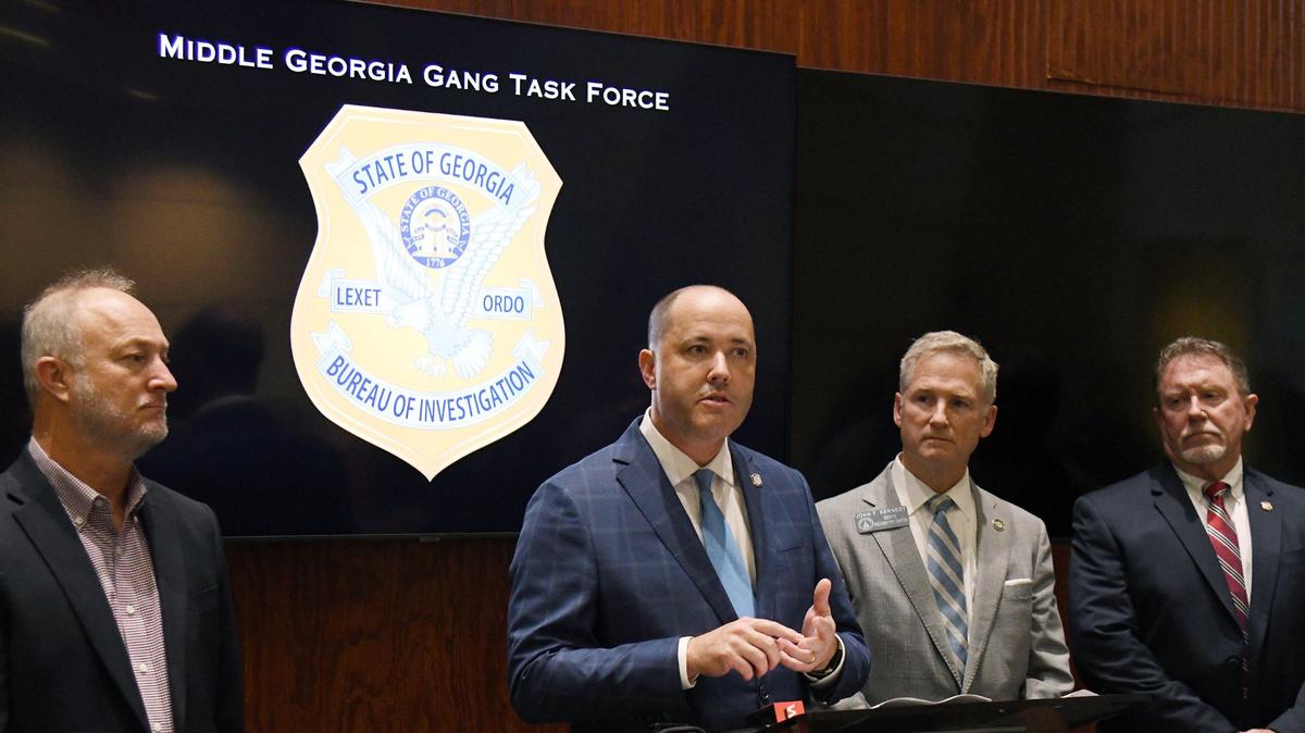 Georgia Attorney General Chris Carr (middle) speaks about the progress of the Middle Georgia Gang Task Force next to Bibb County Mayor Lester Miller (left), Georgia State Senate Pro Tempore John F. Kennedy (right) and Georgia Bureau of Investigation director Chris Hosey (far right) on Wednesday, June 26, 2024, in the GBI task force office in Macon, Georgia. Carr said in the conference that the task force has initiated over 200 gang-related cases since it started work in Macon last year.