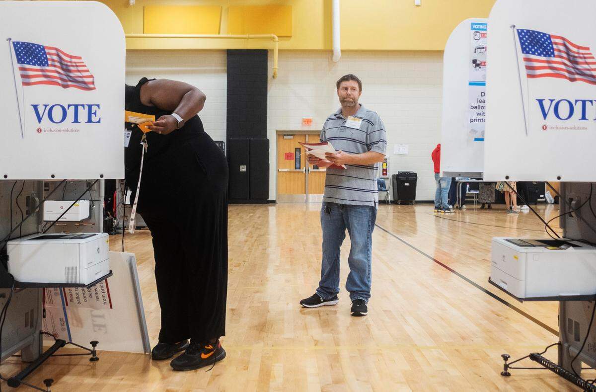 Republican poll watcher Brad Emerton examined each voting machine, making sure vote counts were at zero, as officials set up the East Macon 3 voting precinct Tuesday morning