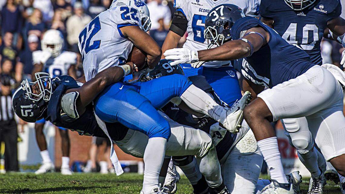 Georgia Southern defensive lineman Jamal Johnson (51) brings down Georgia State wide receiver Taz Bateman (22) during Saturday's game in Statesboro.