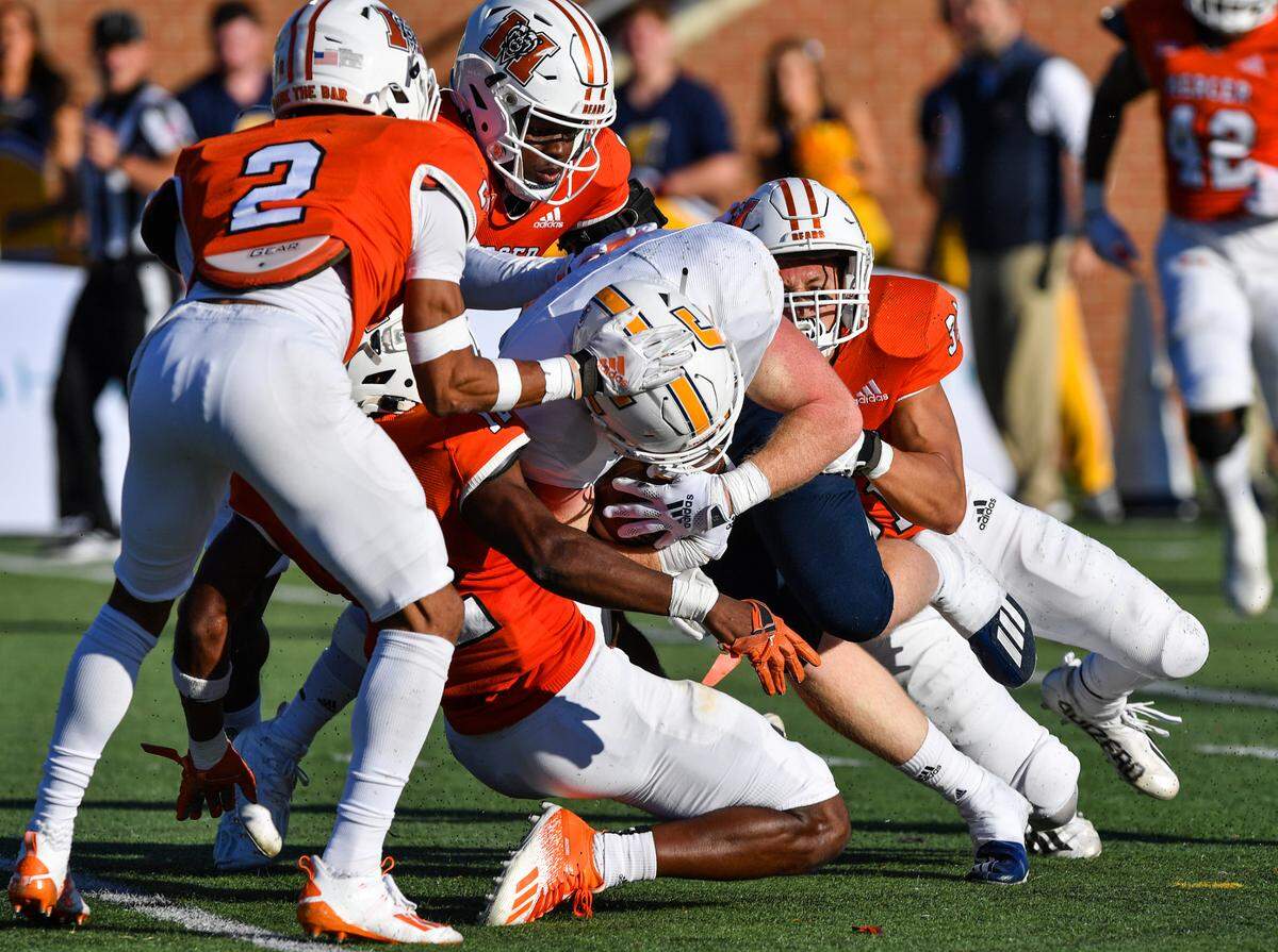 UTC tight end Chris James is hauled down by a host of Mercer defenders after a short pass reception.