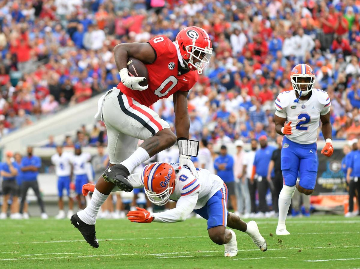 Georgia tight end Darnell Washington leaps over a Florida defender and heads for a first down Saturday in Jacksonville as the Dawgs beat Florida 42-20