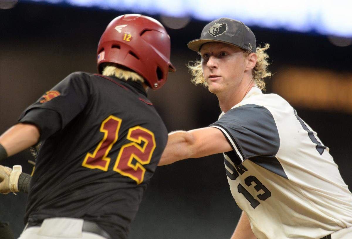Houston County pitcher Coleman Willis (13) tags out a Lassiter batter before reaching first base during game two of their GHSA 6A Championship series Wednesday in Atlanta.