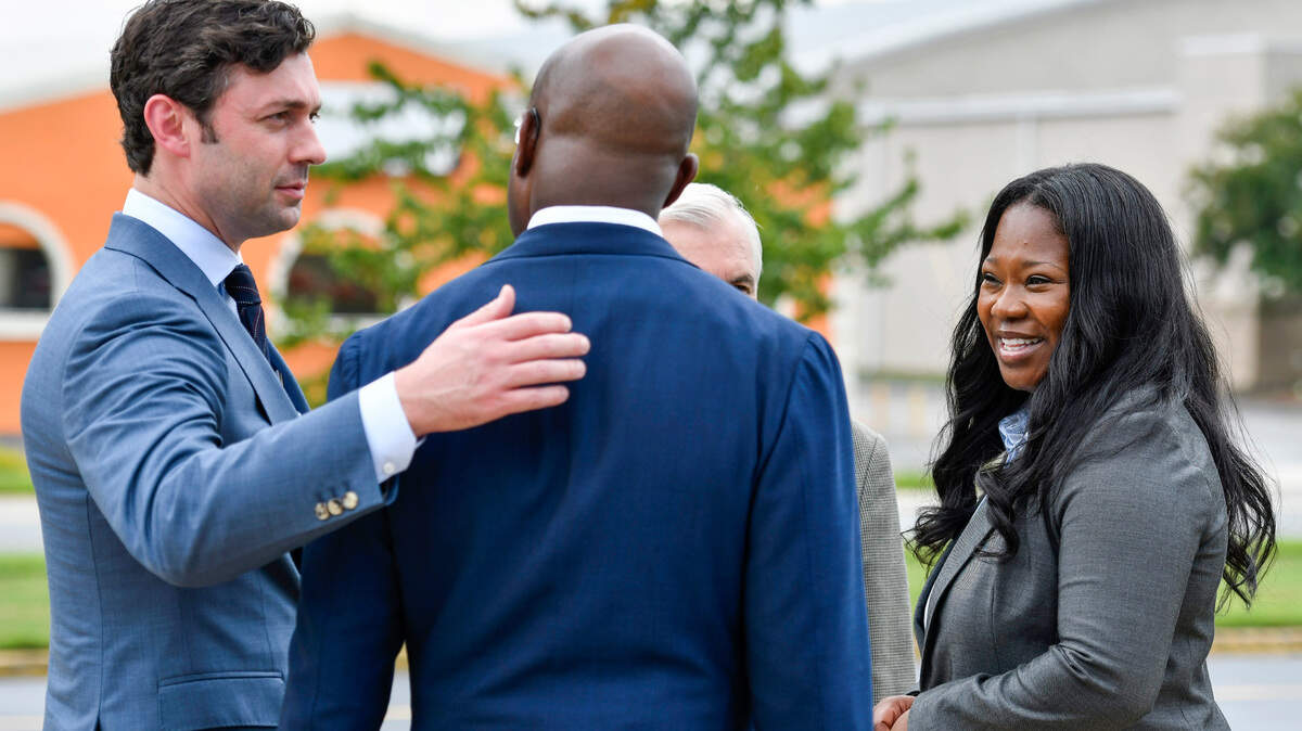 Warner Robins Mayor LaRhonda Patrick, right, speaks with U.S. Senators Jack Reed (D-RI), Reverend Raphael Warnock (D-GA) and Jon Ossoff (D-GA) after a press conference outside Warner Robins City Hall Wednesday afternoon.