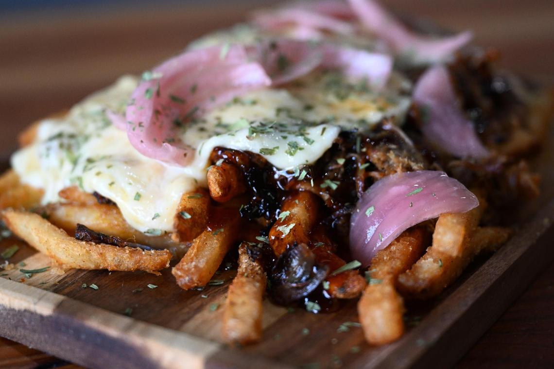 “The Gouda Pig”, Social Duck’s 2025 Downtown Macon French Fry Fight submission, sits on the table inside the restaurant on Thursday, July 3, 2025, in Macon, Georgia. The dish featured BBQ seasoned fries with melted Gouda, BBQ sauce and pickled red onions.