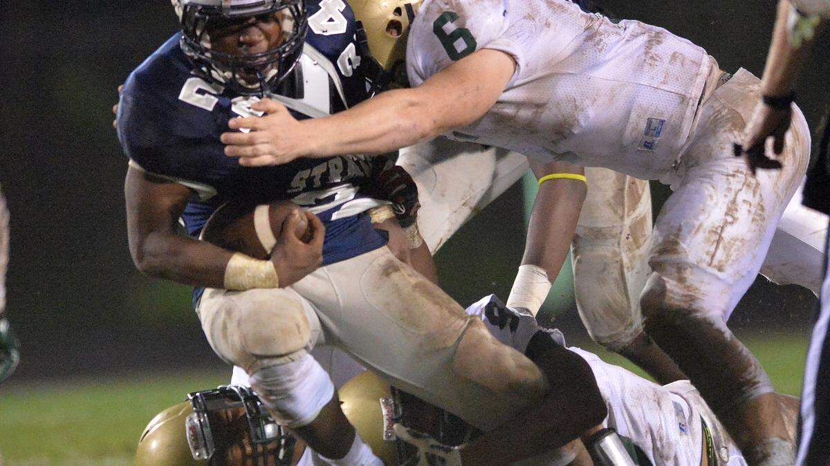 Stratford's Kasey Sanders get hauled down near the line of scrimmage by Aquinas defender Burke Agee.
