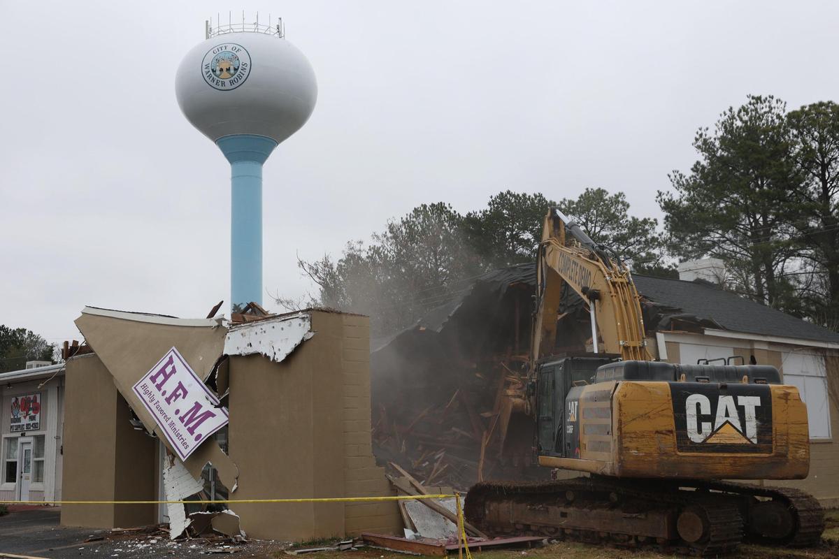 An excavator destroys 401 N. Commercial Circle, which housed Highly Favored Ministries, on Wednesday, Feb. 19, 2025, in Warner Robins, Georgia. The demolition is the fourth in series of Warner Robins demolitions as a part of the city’s “Operation Reawaken” initiative to destroy blight and rebuild.
