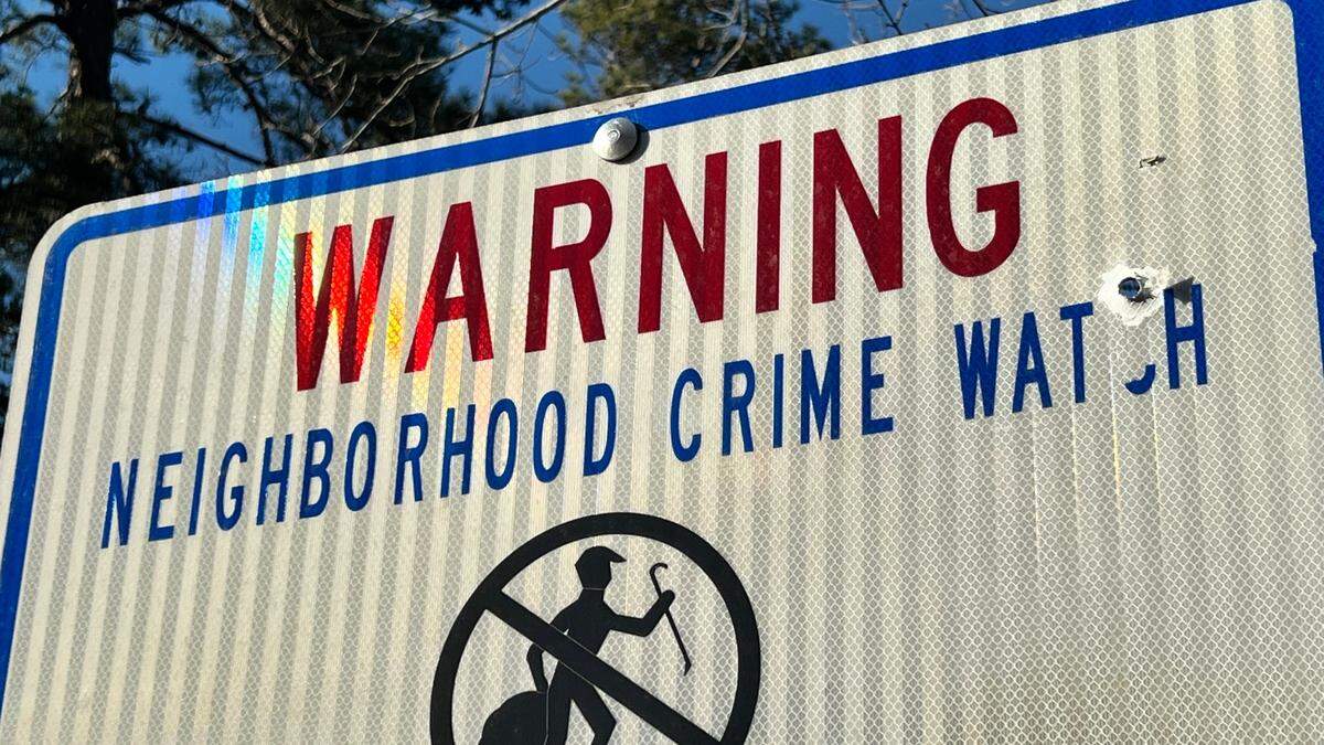 A neighborhood crime watch sign with a bullet hole in it in a Macon neighborhood along General Winship Avenue, where a suspect fired more than a dozen rounds at an undercover Bibb County deputy.