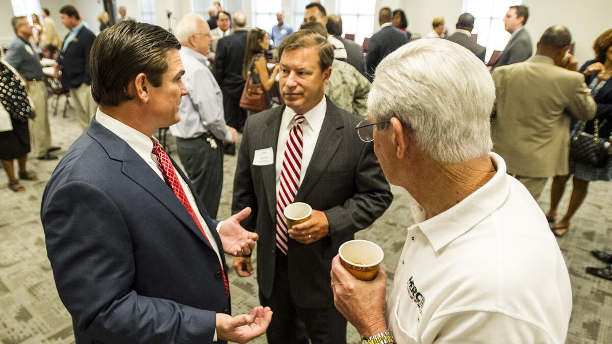 U.S. Rep. Austin Scott talks with John Hall and David Barwick at the Robins Regional Chamber of Commerce Coffee with the Congressmen.