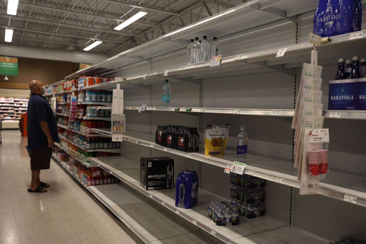 A shopper at a Warner Robins Publix looks for items before Hurricane Helene reaches Middle Georgia. The store was packed Thursday, and many necessities were in low supply as customers stocked up.
