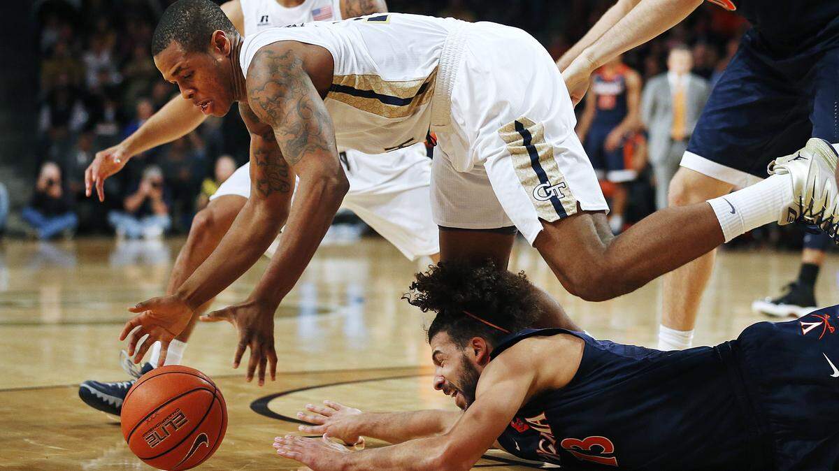 Georgia Tech's Marcus Georges-Hunt, top, dives for a loose ball against Virginia's Anthony Gill in the first half of an NCAA college basketball game Saturday, Jan. 9, 2016, in Atlanta. (AP Photo/David Goldman)