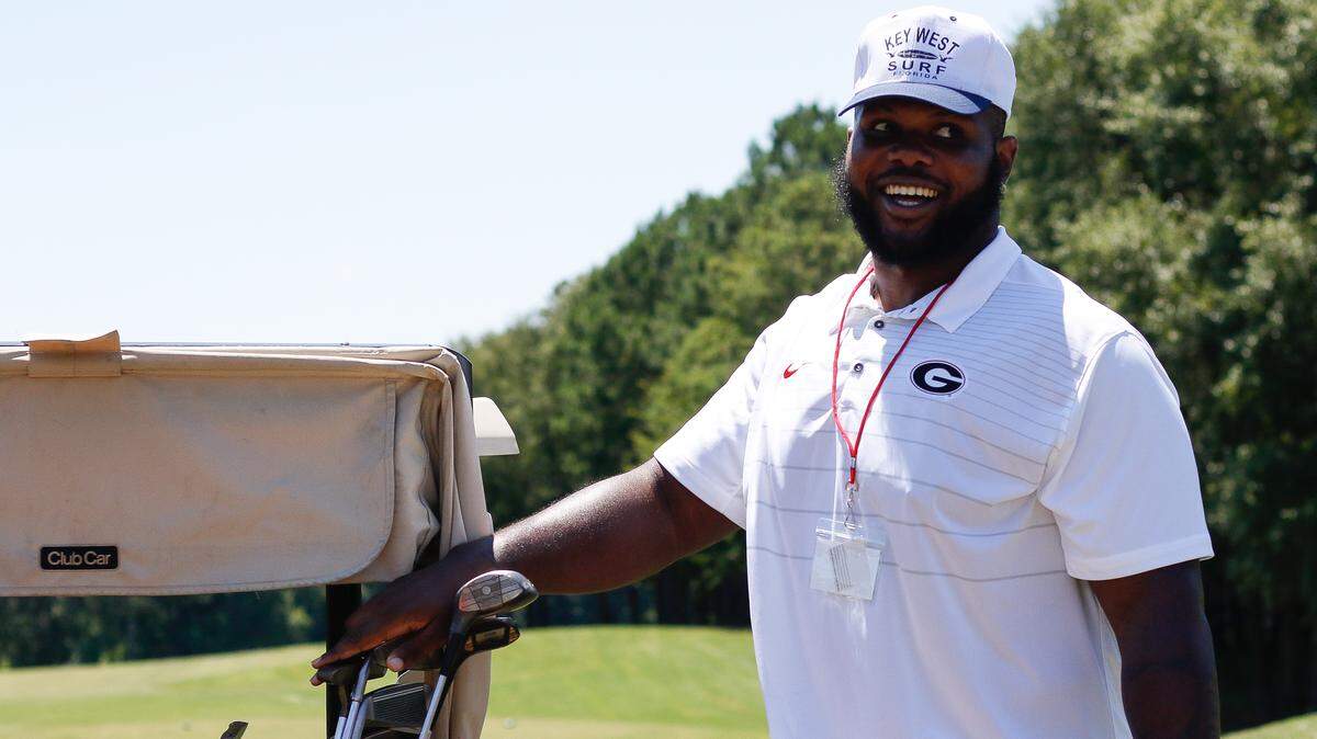 Georgia defensive end Jay Hayes laughs at one of his tournament teammates at the Bulldogs Battling Breast Cancer golf tournament at The Georgia Club in Statham, Georgia, on Monday, July 9, 2018