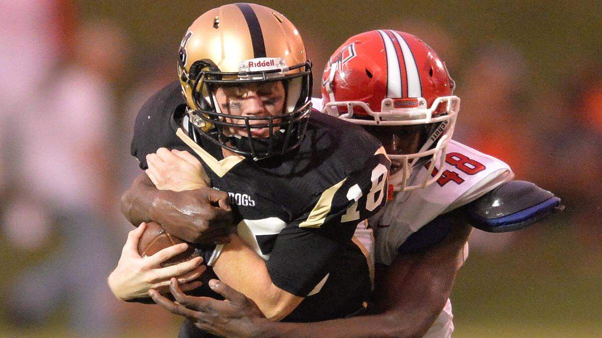 EVAN RODENROTH/For The TELEGRAPH,Forsyth, Georgia, 08/28/2015: Mary Person quarterback Jake Johnston gets brought down at behind the line of scrimmage by Jackson Red Devil Juwan Watkins.