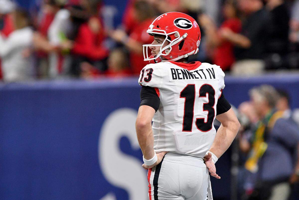 Georgia quarterback Stetson Bennett (12) looks toward the sidelines Saturday during the Bulldogs’ SEC Championship game against Alabama.