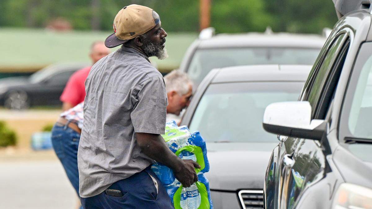 Volunteers and city workers hand out cases of water at the Baldwin County Government Center in Milledgeville Thursday afternoon. The city gave out 864 cases of drinkable water Wednesday night.